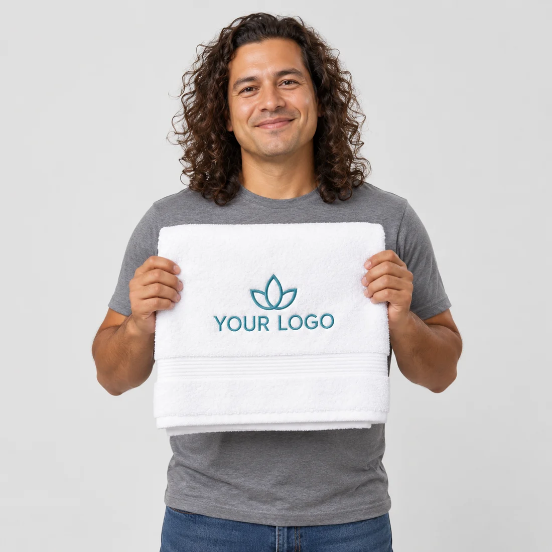 Model holding a white towel with teal YOUR LOGO embroidery