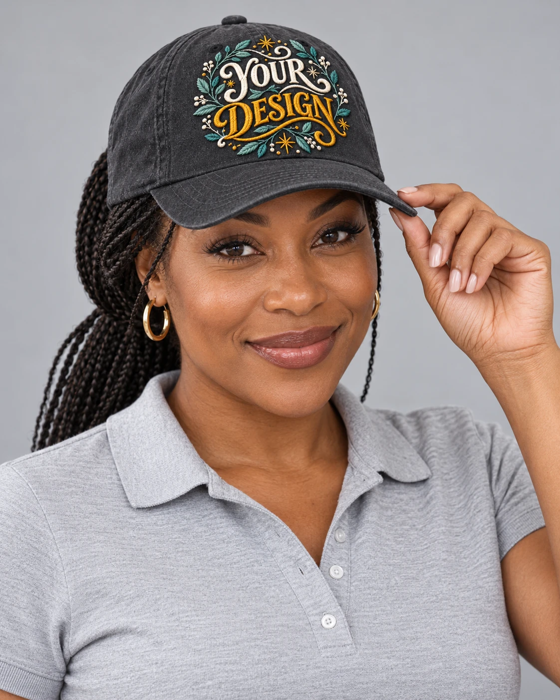 Adult wearing a charcoal cap with decorative YOUR DESIGN embroidery