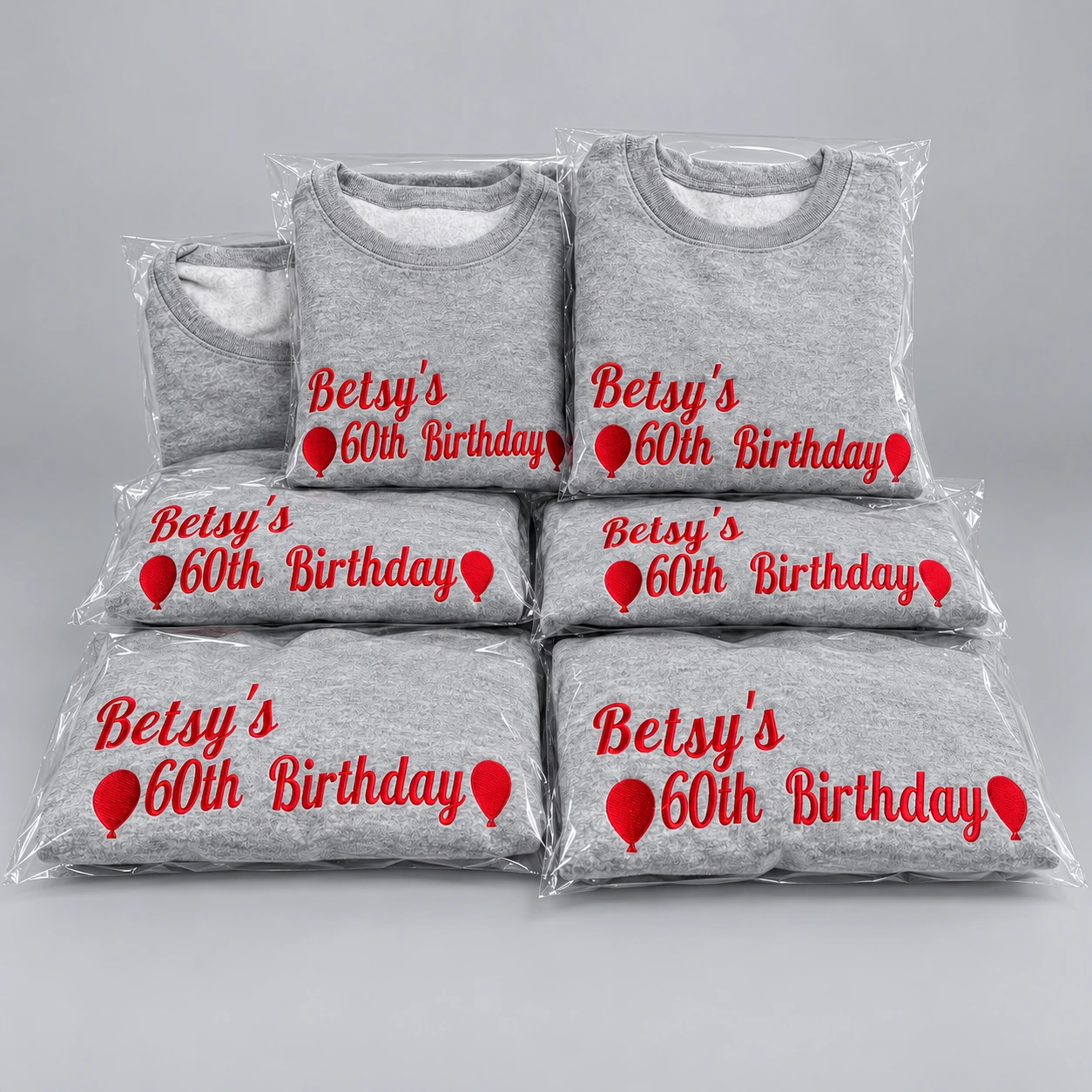 Packaged gray sweatshirts with red birthday embroidery